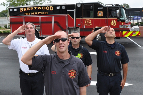 Firefighters salute the flag during the National Anthem.